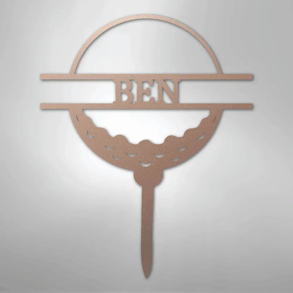 Rose gold metal golf ball monogram wall art with "BEN" cut out, featuring a tee base.