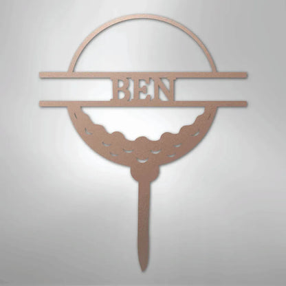 Rose gold metal golf ball monogram wall art with "BEN" cut out, featuring a tee base.