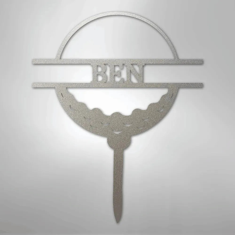 Silver metal golf ball monogram wall art with "BEN" cut out, featuring a textured finish.