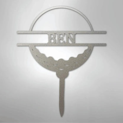 Silver metal golf ball monogram wall art with "BEN" cut out, featuring a textured finish.