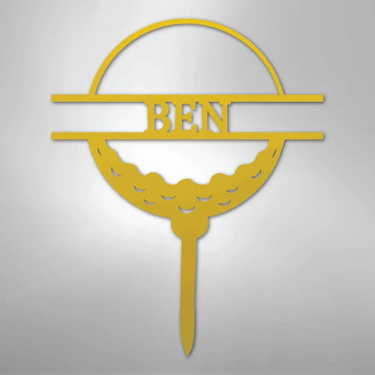 Gold metal golf ball monogram wall art with "BEN" in the center, on a tee.