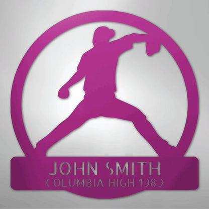 Pink metal wall art featuring a baseball pitcher silhouette within a circle, personalized with "JOHN SMITH" and "COLUMBIA HIGH 1989".