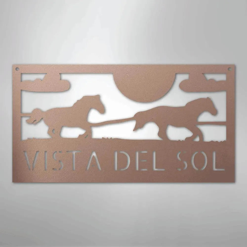 Copper-toned metal sign with two racing horses, sun, clouds, and "VISTA DEL SOL" cut out.