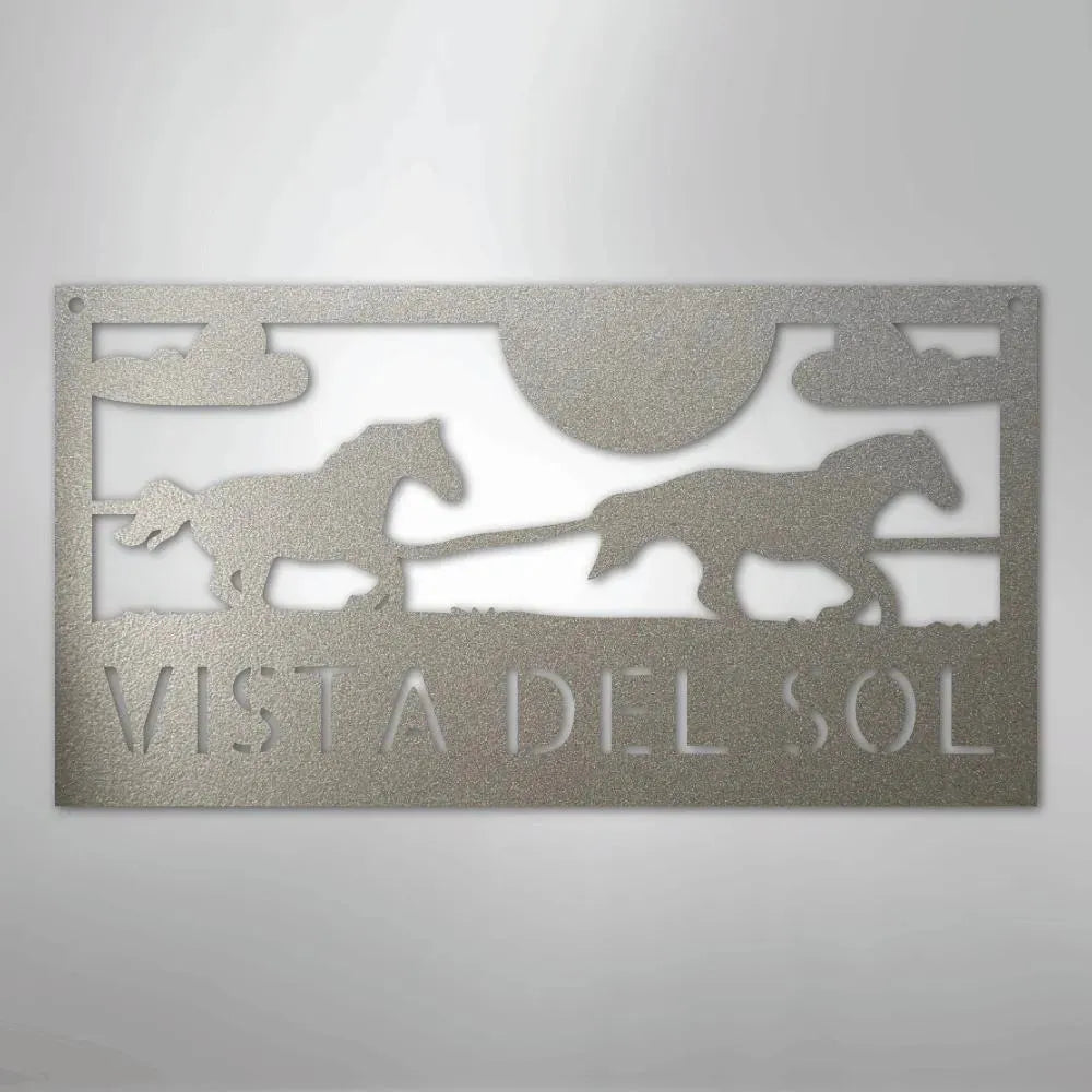 Silver metal sign with two racing horses, sun, clouds, and "VISTA DEL SOL" text.