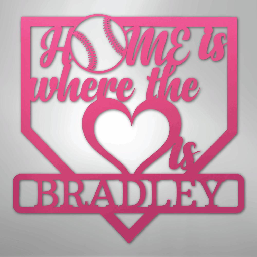 Pink metal baseball home plate sign with "Home is where the heart is Bradley" text and a baseball.