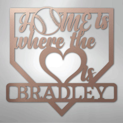 Rose gold metal baseball home plate sign with "Home is where the heart is Bradley" text.