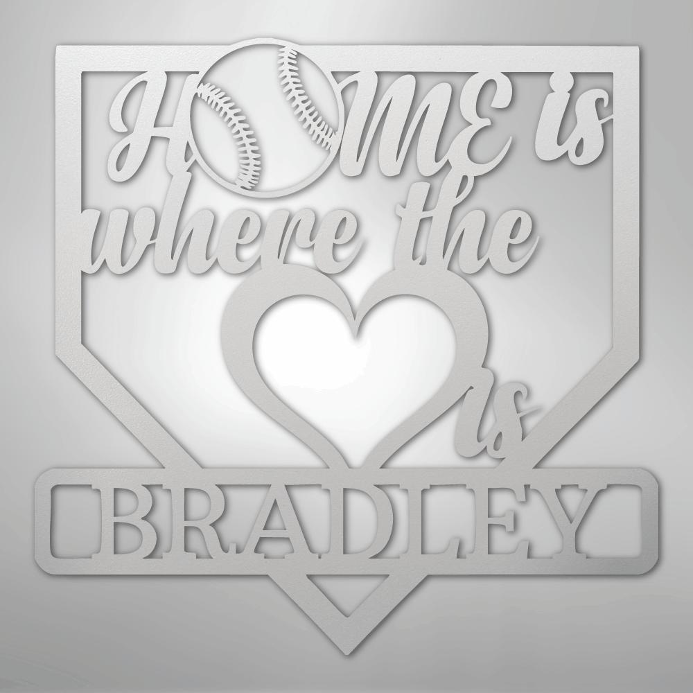 White metal baseball home plate sign with "Home is where the heart is" and "BRADLEY" cut out.