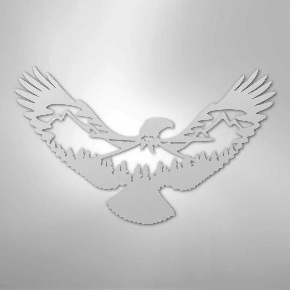 White metal wall art featuring an eagle silhouette with mountains and trees within its wings.