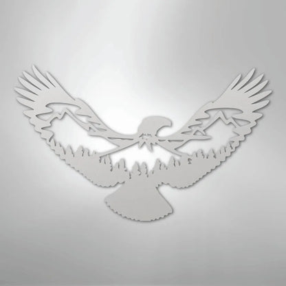 White metal wall art featuring an eagle silhouette with mountains and trees within its wings.