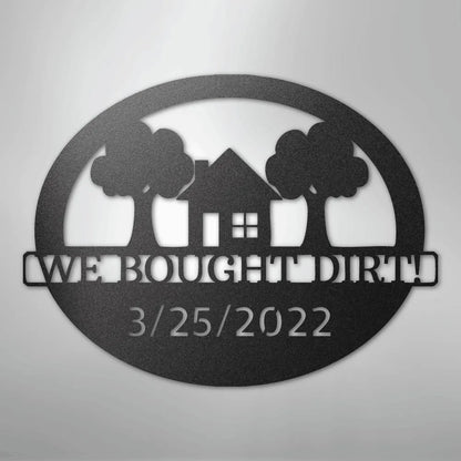 Black metal oval wall art with "WE BOUGHT DIRT!" and "3/25/2022" text, house, and trees.