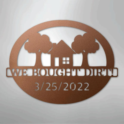 Copper-colored oval metal wall art with "WE BOUGHT DIRT" and "3/25/2022" text, featuring a house and two trees.