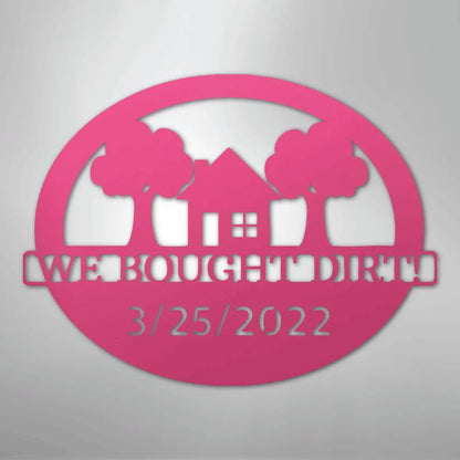 Pink oval metal wall art with "WE BOUGHT DIRT" and "3/25/2022" text, house, and trees.