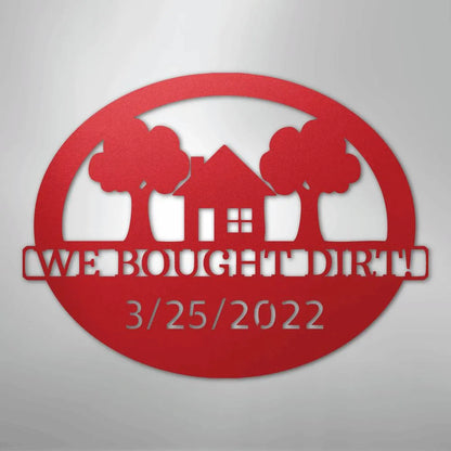 Red metal "We Bought Dirt" wall art with a house, trees, and "3/25/2022" in an oval design.