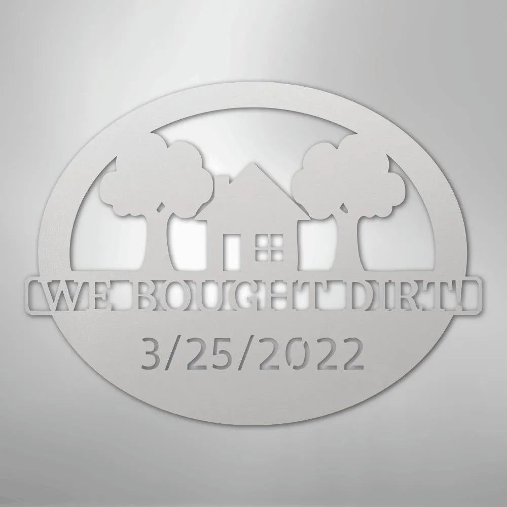 Silver metal wall art: "WE BOUGHT DIRT" with a house, trees, and "3/25/2022" in an oval design.