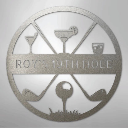 Silver metal "ROY'S 19TH HOLE" monogram sign with golf clubs, ball, and cocktail glasses.