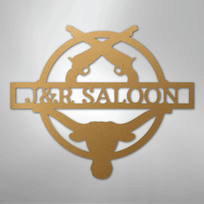 Gold metal "J&R Saloon" monogram wall art with crossed pistols and bull skull design.