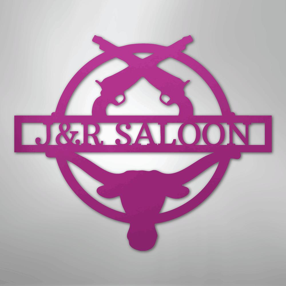 Pink metal "J&R Saloon" monogram with crossed pistols and a longhorn skull design.
