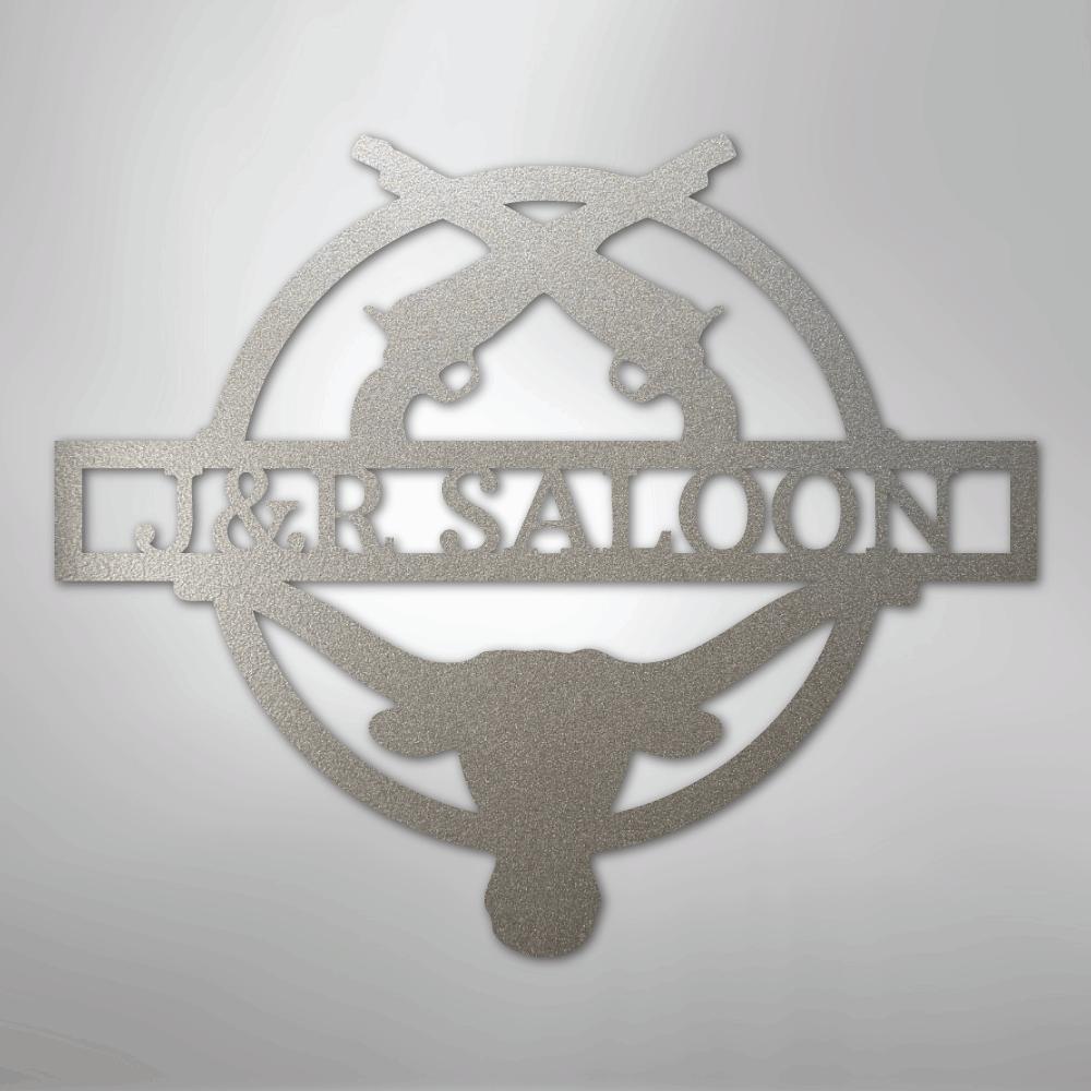 Silver metal "J&R Saloon" monogram wall art with crossed pistols and a longhorn skull design.