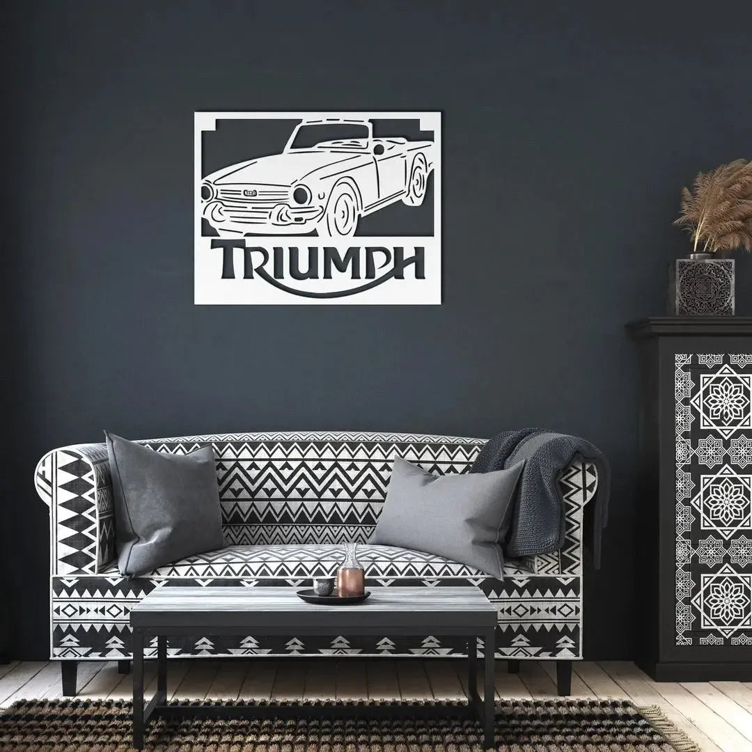 Sofa with patterned cushions and a Triumph car decal on a dark wall.