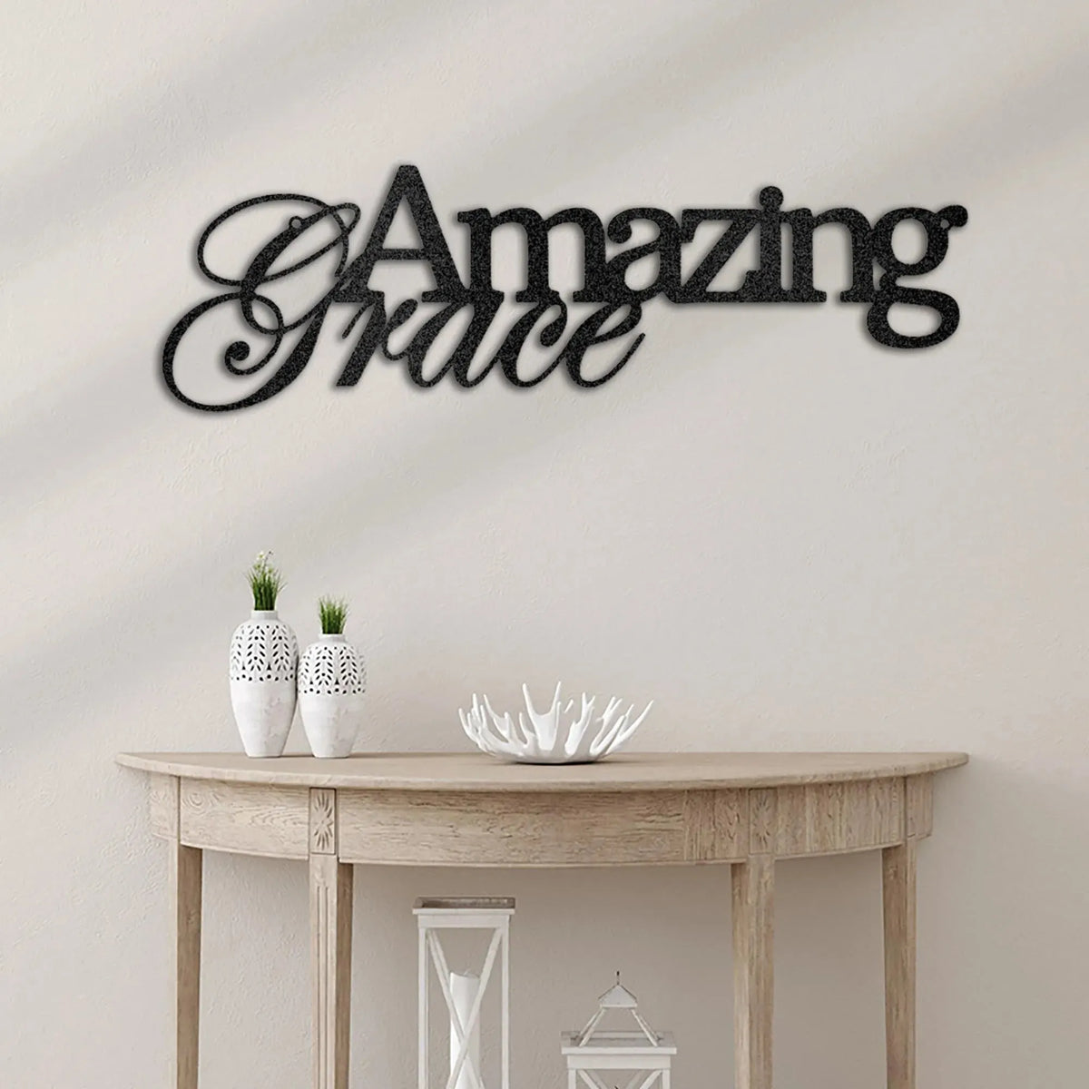 Black "Amazing Grace" metal wall art in a script font, displayed above a wooden console table.