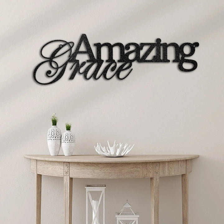 Black "Amazing Grace" metal wall art in a script font, displayed above a wooden console table.