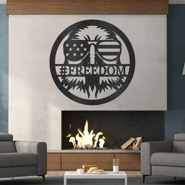 Black metal "FREEDOM" sign featuring an eagle wearing American flag sunglasses, mounted above a modern fireplace.