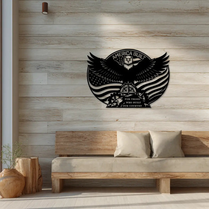 Decorative wall art with an eagle design and 'America Built' text on a wooden wall above a sofa.