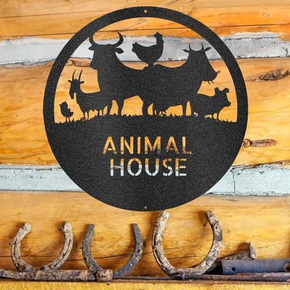Black powder-coated steel "Animal House" monogram with farm animal silhouettes, hanging on a log wall.