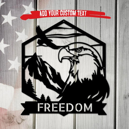 Black metal bald eagle monogram wall art with mountains, trees, and "FREEDOM" banner, on a distressed American flag background.