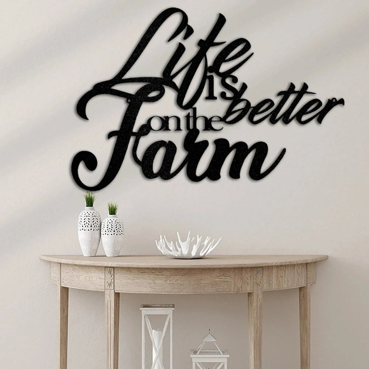 Black metal "Life is Better on the Farm" wall art in script font, displayed above a wooden console table.