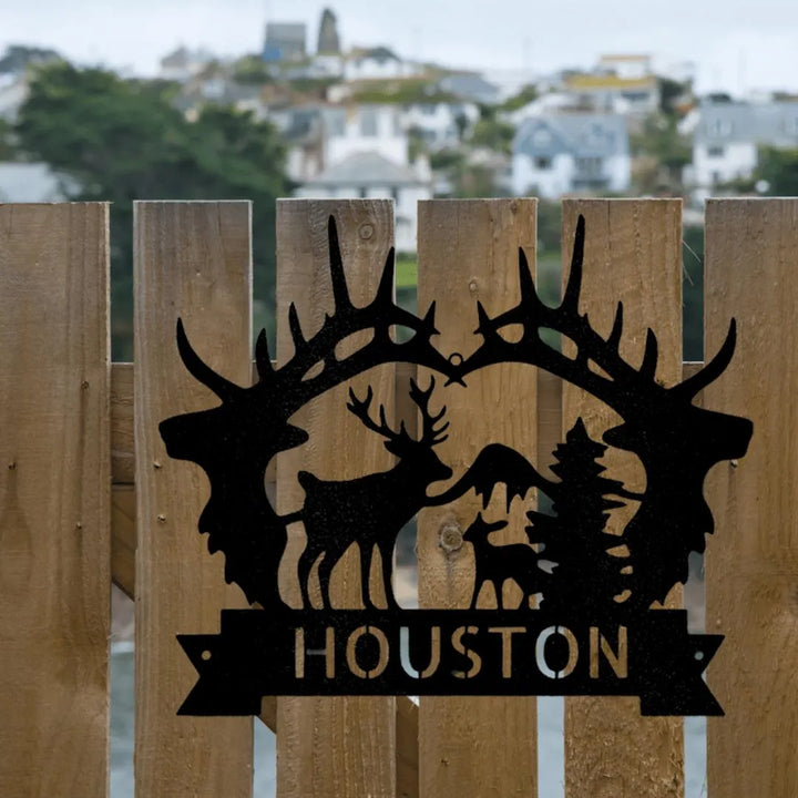 Black metal deer antler monogram with a buck, doe, and fawn, featuring "HOUSTON" on a banner.