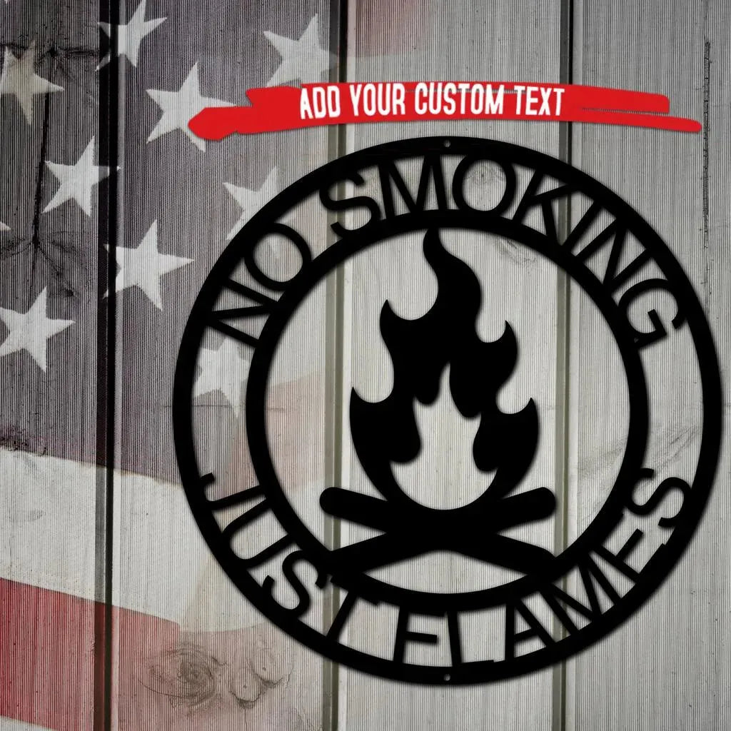 Black metal campfire monogram wall art with "NO SMOKING JUST FLAMES" text, on a rustic wood and flag background.