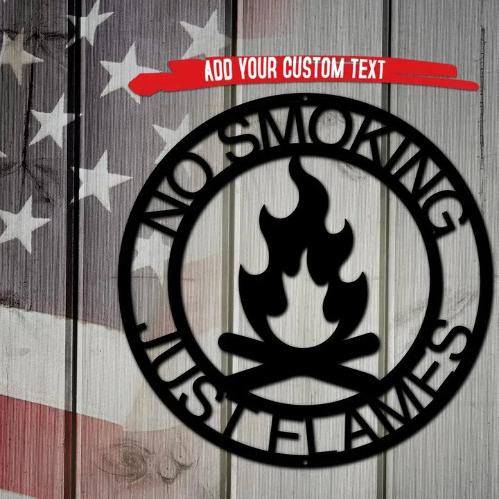 Black metal campfire monogram wall art with "NO SMOKING JUST FLAMES" text, on a rustic wood and flag background.