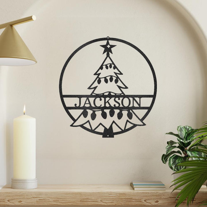 Black metal Christmas tree wall art with "JACKSON" cut out, framed in a circle.