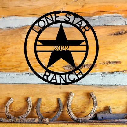 Black metal "Lone Star Ranch 2022" monogram with a star, mounted on a rustic log wall.