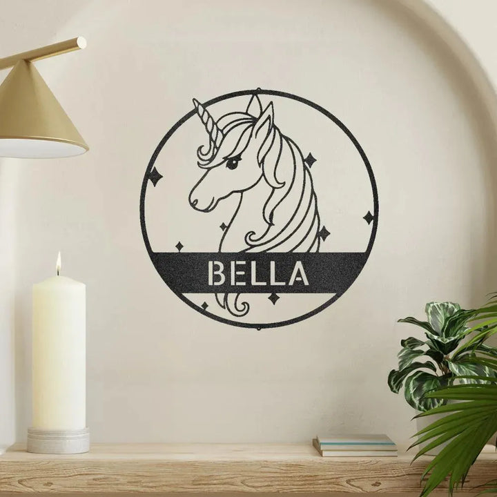 Black metal unicorn monogram wall art with "BELLA" name, set in a circular frame with stars.