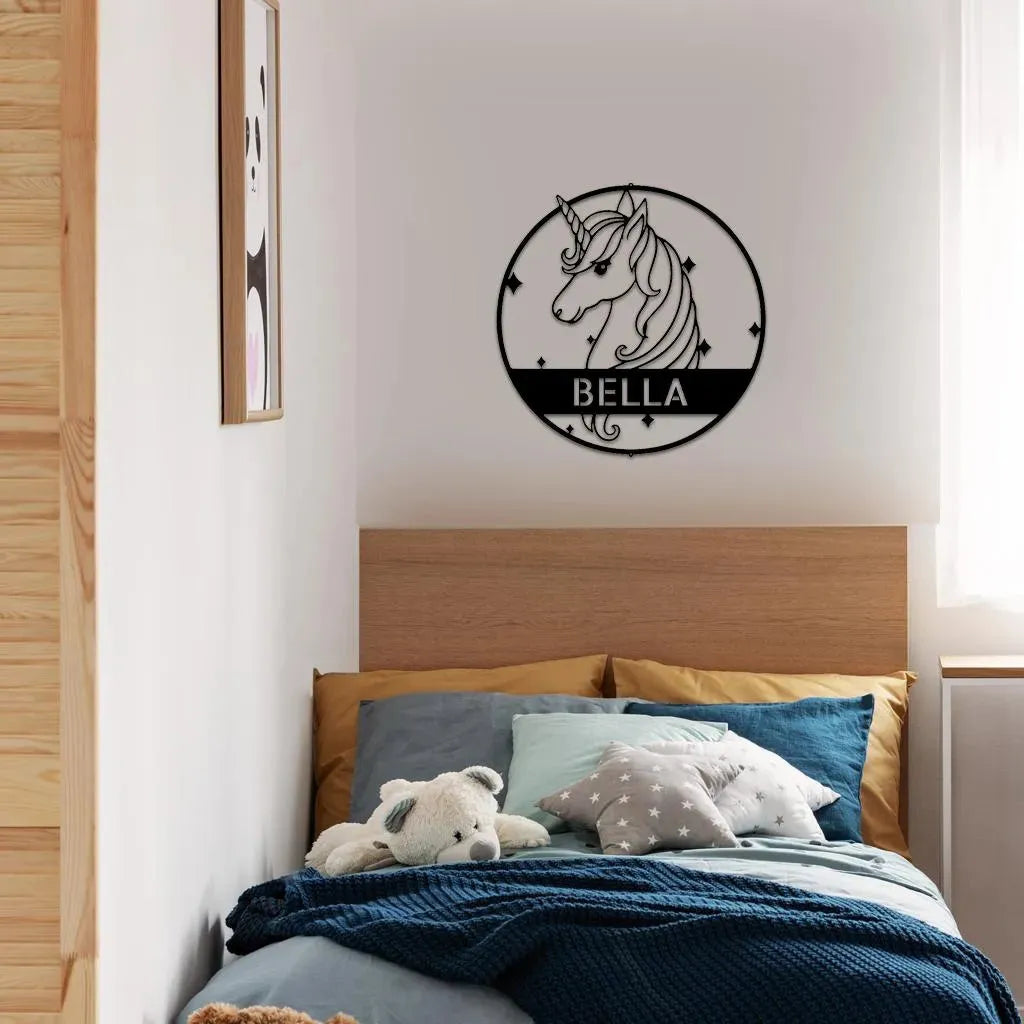 Black metal unicorn monogram wall art with "BELLA" in a child's bedroom.