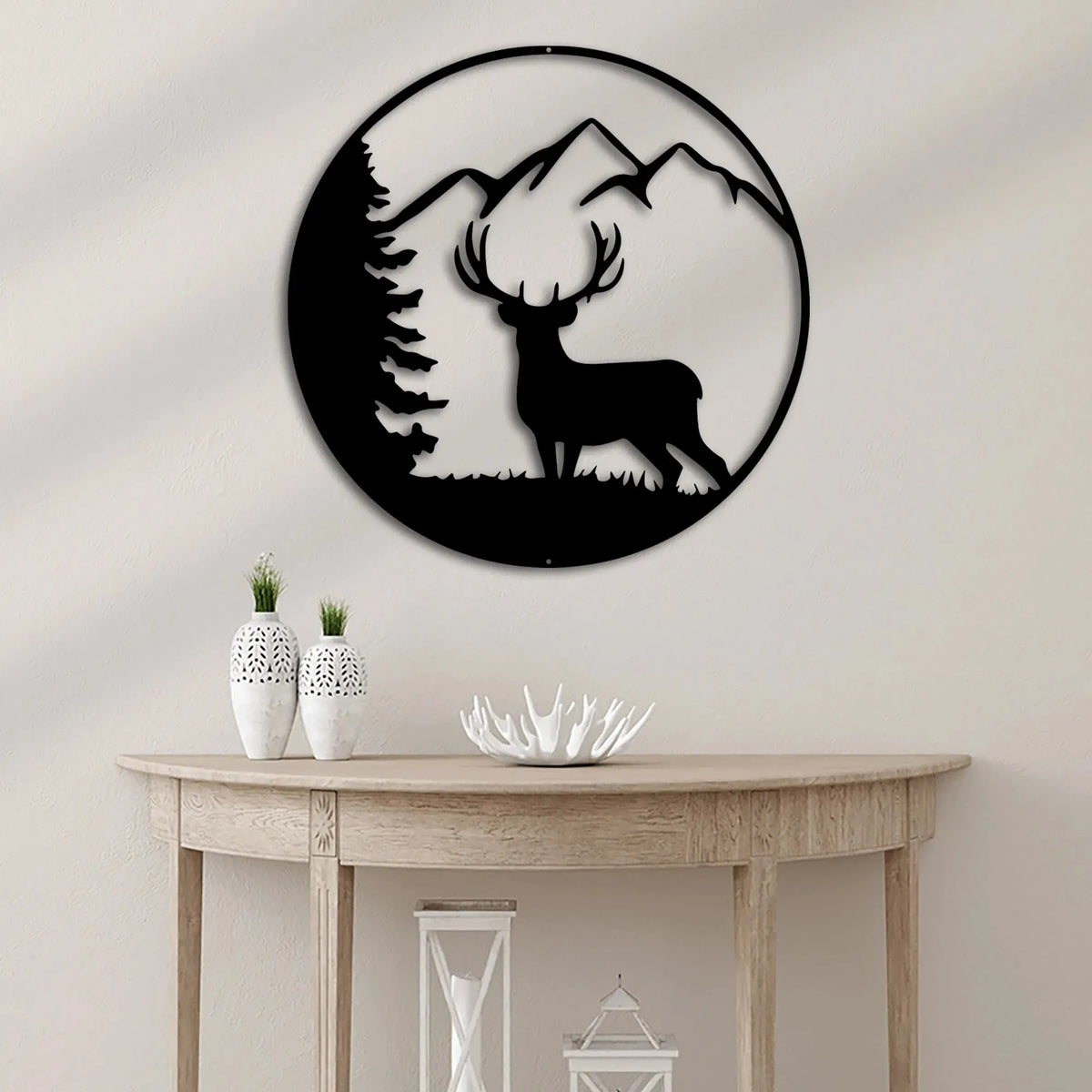 Black metal deer head wall art with mountain and tree silhouette design in a circular frame.