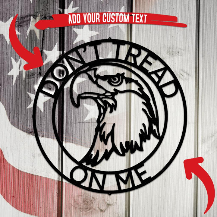 Black metal "Don't Tread On Me" eagle head ring monogram wall art on a rustic American flag background.