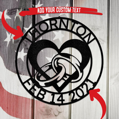 Black metal engagement heart and rings wall art with custom text "THORNTON FEB 14 2021" on a flag background.