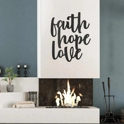 Black metal "Faith Hope Love" script wall art above a modern fireplace.
