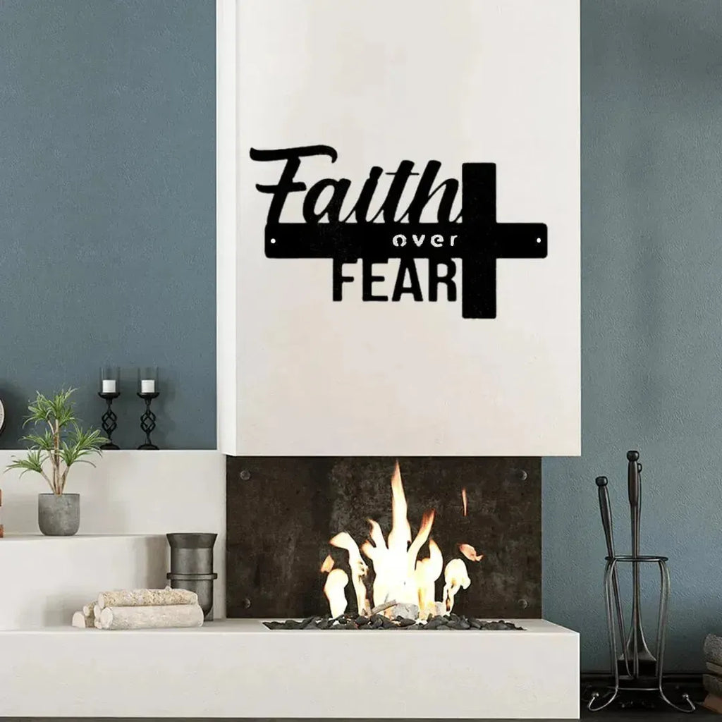 Black metal "Faith over Fear" wall art with a cross design, displayed above a modern fireplace.