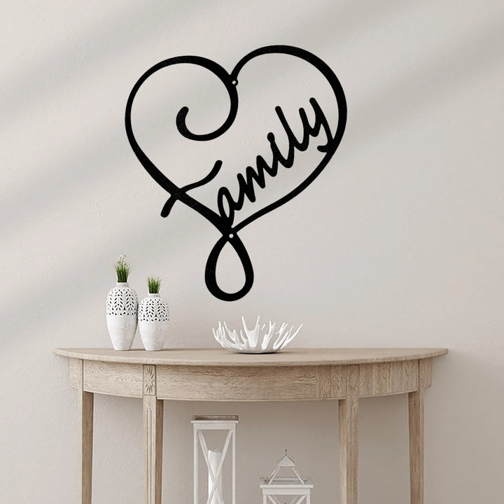 Black metal heart-shaped wall art with "Family" script, displayed above a wooden console table.
