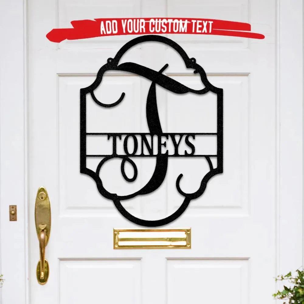 Black metal family name plaque with ornate frame, large initial "T", and "TONEYS" text on a white door.