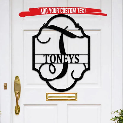 Black metal family name plaque with ornate frame, large initial "T", and "TONEYS" text on a white door.