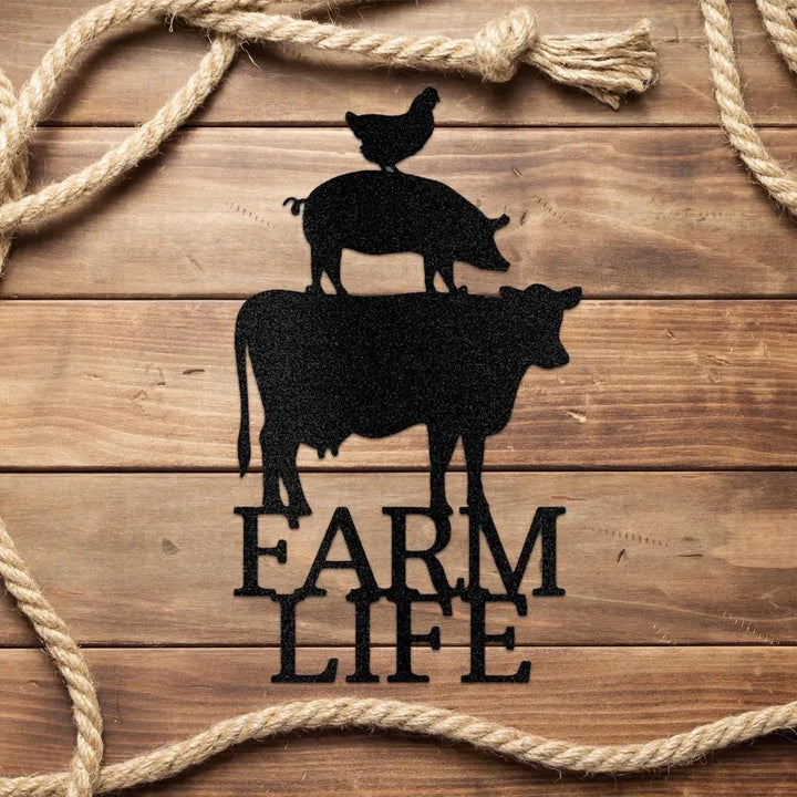 Black metal farm animal art: cow, pig, chicken stacked, with "FARM LIFE" text, on wood with rope.