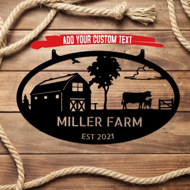 Black metal oval wall art with a barn, cow, calf, tree, and custom text "MILLER FARM EST 2021".