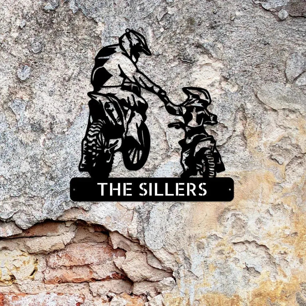 Black metal wall art depicting a father and son on motocross bikes, with a custom nameplate "THE SILLERS".