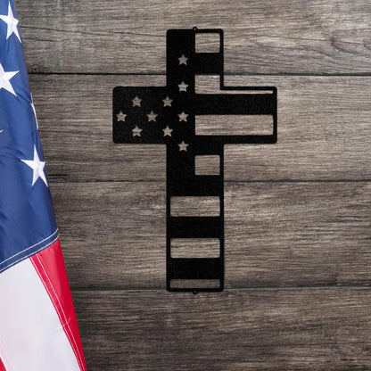 Black metal cross wall art with American flag design, stars, and stripes, on a wooden background.