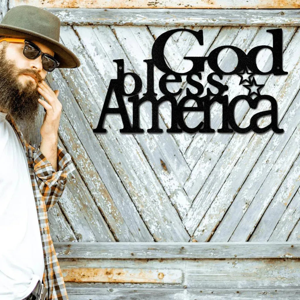 Black metal "God Bless America" wall art with a star, displayed on a distressed wooden background.